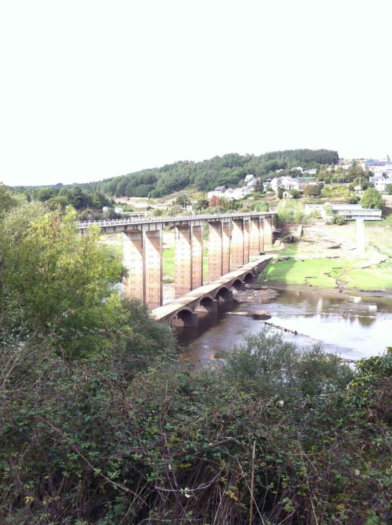 Exceptionally tall bridge crossing a very shallow river in Portomarin