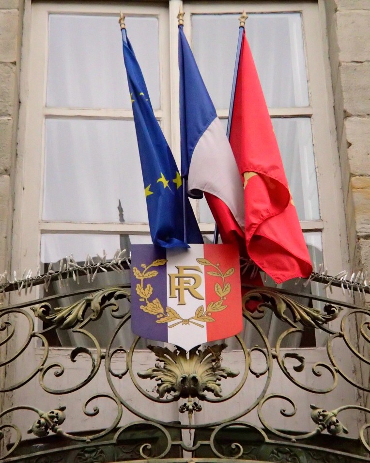 The flags of the European Union, France, and Languedoc region outside the Mairie (Town Hall.)