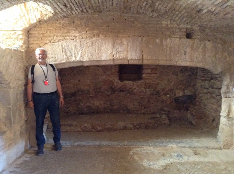Alan standing beside the huge fireplace in the kitchen.